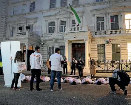  ?? AP ?? Activists gather outside the Iranian Embassy in London in a show of internatio­nal solidarity with anti-government protests in Iran on Monday.