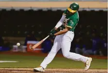  ?? Jeff Chiu / Associated Press ?? Matt Olson connects for a three-run single to highlight the A’s six-run second inning in their win over Texas at the Coliseum.