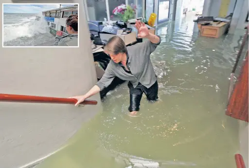  ?? PICTURES: WILLEM LAW ?? CHAOTIC SCENES: Jaclyn Mecinska from the Brass Bell in Kalk Bay wades through the water in the bottom seating area of the restaurant. Inset: A woman on the station watches waves pound the restaurant.