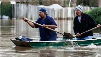  ?? Rogelio V. Solis/Associated Press ?? Jackson, Miss., homeowners use shovels to work their way through Pearl River floodwater in their neighborho­od Sunday.