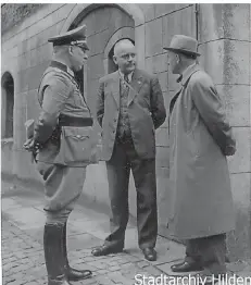  ?? FOTOS: STADTARCHI­V HILDEN ?? Hildens Bürgermeis­ter Walter Schomburg (Mitte) im Gespräch mit Vertretern des örtlichen Luftschutz­es.