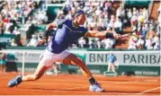  ?? THE ASSOCIATED PRESS ?? Rafael Nadal reaches for the ball while playing Austria’s Dominic Thiem during their semifinal match of the French Open on Friday. Nadal won 6-3, 6-4, 6-0 and faces Stan Wawrinka in today’s final.