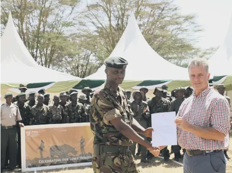  ??  ?? POWER RANGER: Edward Ndiritu being presented with a letter notifying him of his award by Lewa chief executive officer Mike Watson.