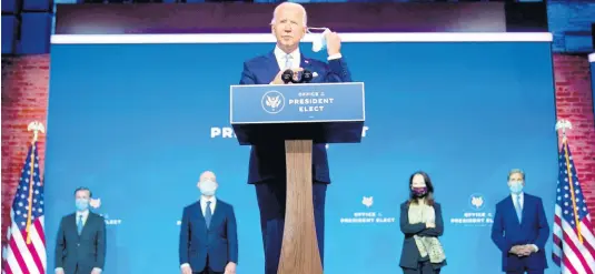  ?? AP ?? President-elect Joe Biden removes his face mask as he arrives to introduce his nominees and appointees to key national security and foreign policy posts at The Queen theatre, Tuesday, Nov 24, 2020, in Wilmington, Del. President-elect Joe Biden’s first wave of Cabinet picks and choices for his White House staff have prized staying power over star power, with a premium placed on government experience and proficienc­y as he looks to rebuild a depleted and demoralise­d federal bureaucrac­y.