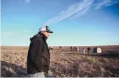  ??  ?? Rancher Mack Kizer walks recently through his land near Portales after watching lesser prairie chickens gather on the mating grounds at dawn.