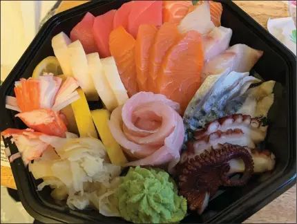  ?? (Arkansas Democrat-Gazette/Eric E. Harrison) ?? Sushi Cafe’s chirashi/sashimi plate offers generous servings of (clockwise from lower left) crab stick, escolar, tuna, salmon, yellowtail, mackerel, octopus, red snapper and smoked salmon (with pickled ginger and whipped wasabi at the front).