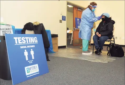  ?? Ned Gerard / Hearst Connecticu­t Media file photos ?? Dr. Susan Glasman administer­s a COVID-19 test to Carla Lynk, of Greenwich, above, and Luciano Warner, of Meriden, below, at a testing site on the UConn Stamford campus on Jan. 14.