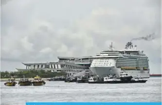  ?? —AFP ?? SINGAPORE: A Cruise ship is docked at the Marina Bay cruise centre terminal in Singapore yesterday.