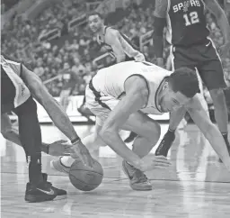  ??  ?? The Suns’ Devin Booker loses the ball against the Spurs on Monday night.