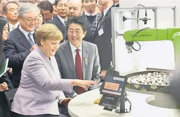  ??  ?? Abe and German Chancellor Angela Merkel looking at a sushi robot at the Hitachi booth during a media tour of the world’s biggest computer and software fair, CeBit, in Hanover, Germany. — Reuters photo