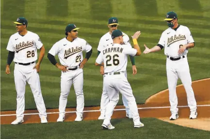  ?? Photos by Scott Strazzante / The Chronicle ?? A’s third baseman Matt Chapman greets team manager Bob Melvin during player introducti­ons before the game.