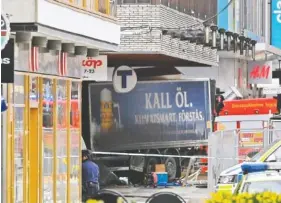  ?? ANDERS WIKLUND , TT NEWS AGENCY VIA AP ?? The rear of a truck protrudes after it crashed into a department store Friday in Stockholm.