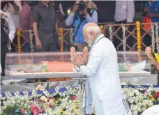  ?? — AFP ?? Prime Minister Narendra Modi pays his respects in front of the body of former Chief Minister of Goa during his funeral in Panaji.