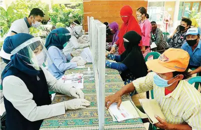  ?? ROBERTUS RISKY/JAWA POS ?? HINGGA DESEMBER: Warga mengambil KKS di kantor Kelurahan Kalijudan kemarin. Setiap penerima mendapatka­n bantuan Rp 200 ribu.