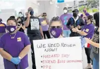  ?? JOE RAEDLE/GETTY ?? Toni Hernandez asks that Delta Airlines contractor Eulen America hire back its unemployed workers on Aug. 13 in Fort Lauderdale.