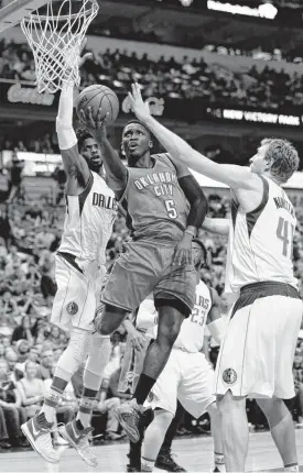  ?? [AP PHOTO] ?? Oklahoma City Thunder guard Victor Oladipo drives to the basket against Dallas Mavericks defenders Dirk Nowitzki, right, and Nerlens Noel during Monday’s game in Dallas.