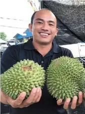  ?? ?? Taste of success: tang (left) and Chia showing off the durians they sell.