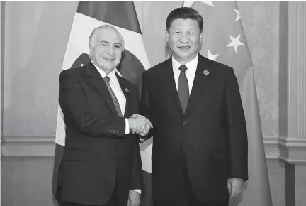  ??  ?? Chinese President Xi Jinping shakes hands with his Brazilian counterpar­t
Michel Temer on the sidelines of the 10th BRICS summit yesterday. Xi called on the two countries to strengthen solidarity and coordinati­on. — Xinhua