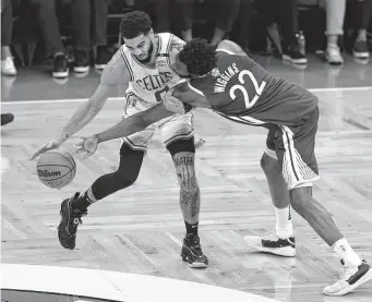  ?? Elsa/Getty Images ?? The Celtics’ Jayson Tatum, left, tries to find a way around the Warriors’ Andrew Wiggins during Game 6 on Thursday night in Boston.