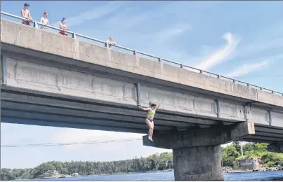 ?? DAVID JALA/CAPE BRETON POST ?? Belle Jacobs of Sydney drops feet first into the Mira River off Albert Bridge on Tuesday while others look on.