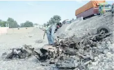  ?? — AFP ?? Afghan security forces inspect the site of a suicide attack targeting foreign troops in the Bati Kot district of Nangarhar province on Monday.