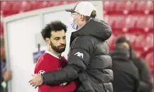  ??  ?? Pep Guardiola celebrates with Phil Foden after the England player scored for Manchester City to secure passage into the Champions League semi-finals. Right, Salah had a poor night in front of goal as Klopp’s side exited the competitio­n.