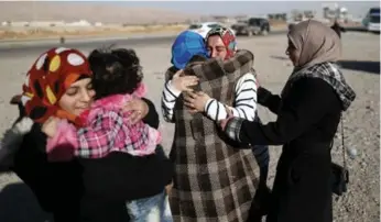  ?? THOMAS COEX/AFP/GETTY IMAGES ?? Some families have reunited after fighting forced them apart, while others in Mosul have had to leave their homes.