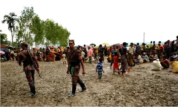  ??  ?? File photo shows members of the Border Guard Bangladesh (BGB) on duty as they detain hundreds of Rohingya refugees in an open area after they crossed the border, in Teknaf, Bangladesh. — Reuters photo