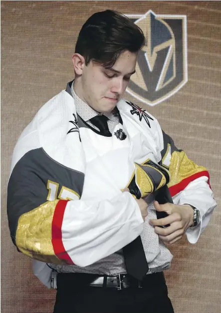  ?? NAM Y. HUH/THE ASSOCIATED PRESS ?? Cody Glass puts on a Vegas Golden Knights jersey after being selected by the team in the NHL draft’s first round on Friday in Chicago. Vegas made three first-round picks on Friday.