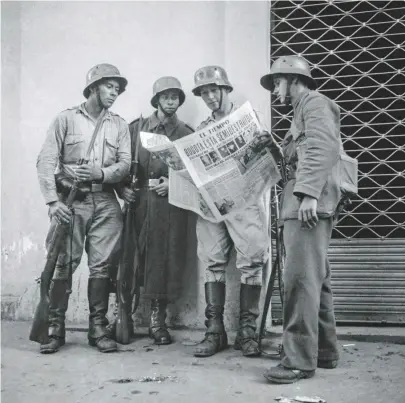  ??  ?? Arriba en el centro: víctimas del 9 de abril en el Cementerio Central de Bogotá, 11 de abril de 1948 Soldados leen la edición de El Tiempo del 12 de abril de 1948