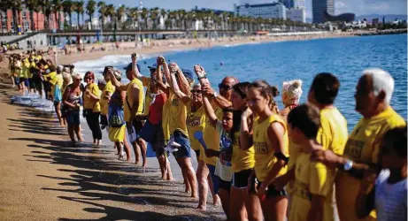  ?? Manu Fernandez / Associated Press ?? Residents form a human chain during a protest against tourism in August in Barcelona. The city has outlined measures to balance the needs of locals and visitors, and it has cracked down on unlicensed rentals.