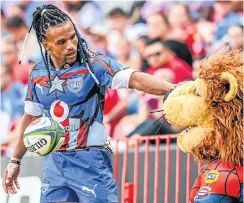  ?? Picture: Gallo Images ?? Rosko Specman of the Bulls rather patronisin­gly pats the Lions’ mascot Mufasa on the head during last week’s 30-12 stampede at Ellis Park.