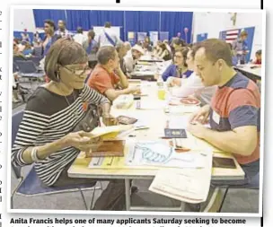  ??  ?? Anita Francis helps one of many applicants Saturday seeking to become American citizens during event at John Jay College in Manhattan.