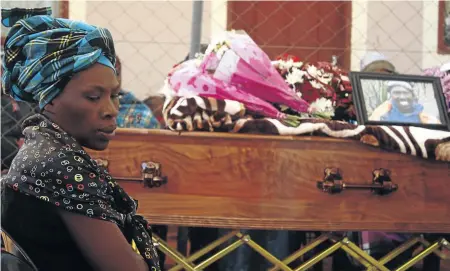  ?? / K A B E LO M O KO E N A ?? Jabulile Mgiqwa next to the coffin of her brother, Vusi Mgiqwa, who was allegedly punched by a white motorist and landed on his head in Selcourt, Springs, on October 26.