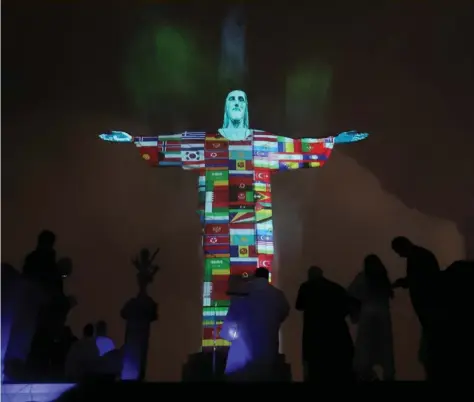  ?? REUTERS/SERGIO MORAES ?? The statue of Christ the Redeemer is lit up in the colours of the countries that are affected by the coronaviru­s outbreak in Rio de Janeiro, Brazil.