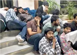  ??  ?? Youth after being detained at the Goshamahal Police Station for participat­ing in the flash protest at Mallepally try to sleep on the footsteps.