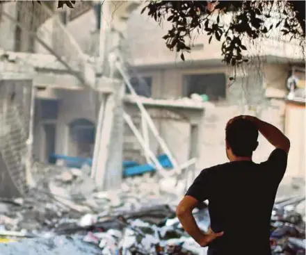  ?? PIC FILE ?? A Palestinia­n man looking at a house which was hit by an Israeli airstrike in Gaza City in 2014.