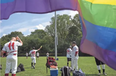  ?? JOSHUA A. BICKEL/COLUMBUS DISPATCH ?? Members of the Alive and Kicking softball team from Ft. Lauderdale, Florida, warm up before a game Wednesday during the Gay Softball World Series at Berliner Sports Park. The competitio­n concludes Saturday.