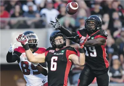  ?? JUSTIN TANG/THE CANADIAN PRESS ?? Redblacks defensive backs Imoan Claiborne, right, and Antoine Pruneau, centre, reach for a ball intended for Stampeders receiver DaVaris Daniels in the Calgary end zone Friday night at TD Place. The teams played to a 31-31 draw.