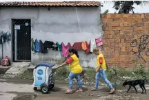  ?? WILLIAM DANIELS/THE NEW YORK TIMES ?? Celene da Silva, one of thousands of door-to-door vendors for Nestlé, and her daughter Sabrina make deliveries in May in Fortaleza, Brazil.