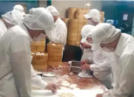  ??  ?? DUMPLING HAND-ROLLERS HARD at work in kitchen of Din Tai Fung Dumpling House Xinyi Branch.