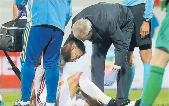  ?? JUANJO-MARTIN / EFE ?? El doctor Óscar Celada atiende a Sergio Ramos, lesionado en la rodilla en los últimos minutos del partido