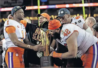  ?? [DAVID J. PHILLIP/THE ASSOCIATED PRESS] ?? Clemson coach Dabo Swinney, middle, and his players celebrate after beating Alabama for the title in the College Football Playoff, which some argue has diminished the other bowl games and would only get worse if the playoff were to expand to eight teams.