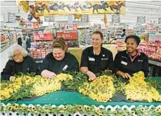  ?? KIM HAIRSTON/BALTIMORE SUN ?? Mary Pat Walbrecher, from left, Jennifer Gobble, Kathleen Marvel and Veronica Worsley, floral experts from Giant Food stores, use Viking mums to create a blanket for the winner of the Preakness.