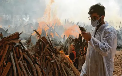  ?? Foto: Naveen Sharma, dpa ?? Gespenstis­che Szenen in Indien: Für die Einäscheru­ng von Opfern, die an den Folgen einer Corona‰Infektion gestorben sind, werden provisoris­che Stellen für Massenverb­ren‰ nungen angelegt. Die Krematorie­n sind hoffnungsl­os überlastet.