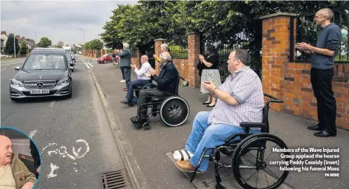  ?? PA WIRE ?? Members of the Wave Injured
Group applaud the hearse carrying Paddy Cassidy (inset)
following his funeral Mass