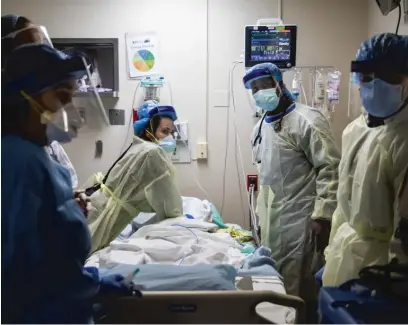  ??  ?? Nurse practition­er Capri Reese (left) watches the monitor for a heart rhythm while respirator­y therapist Khafran Alshahin performs chest compressio­ns on an 80-year-old man who ultimately died from COVID-19 at Roseland Community Hospital in April.