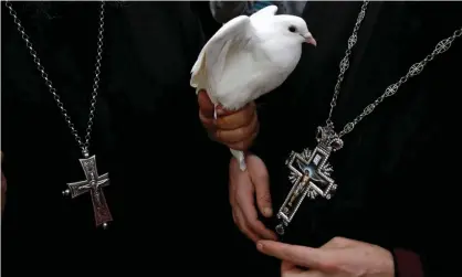  ??  ?? Greek Orthodox priests. The church opposes any funeral rites other than burial. Photograph: Baz Ratner/Reuters