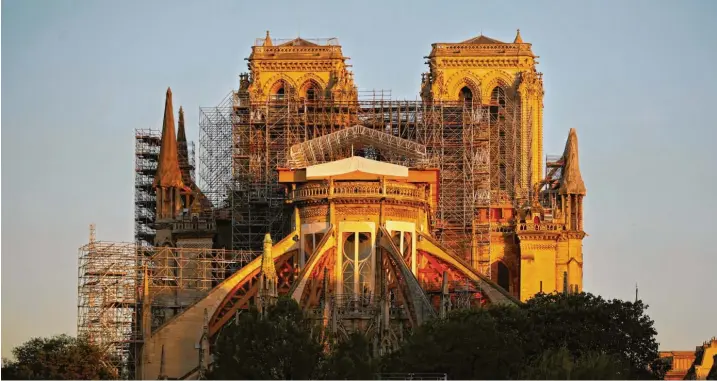  ??  ?? Notre-Dame strahlt an diesem Apriltag 2020 im Licht der aufgehende­n Sonne. Vor genau einem Jahr hatte eine Feuersbrun­st den Himmel rot erleuchtet. Frankreich­s Präsident versprach damals, die Kathedrale innerhalb von fünf Jahren komplett renovieren zu lassen. Doch der Plan ist unwahrsche­inlicher denn je, die Baugerüste sind leer. Fotos: Thomas Coex/afp via Getty Images, Birgit Holzer, Ludovic Marin/Pool afp/ap/dpa