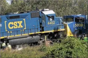  ?? RICK KAUFFMAN — DIGITAL FIRST MEDIA ?? Workers from CSX work to separate two trains that collided head-on, injuring a couple of crew members and leaving a fuel spill to be cleaned up.